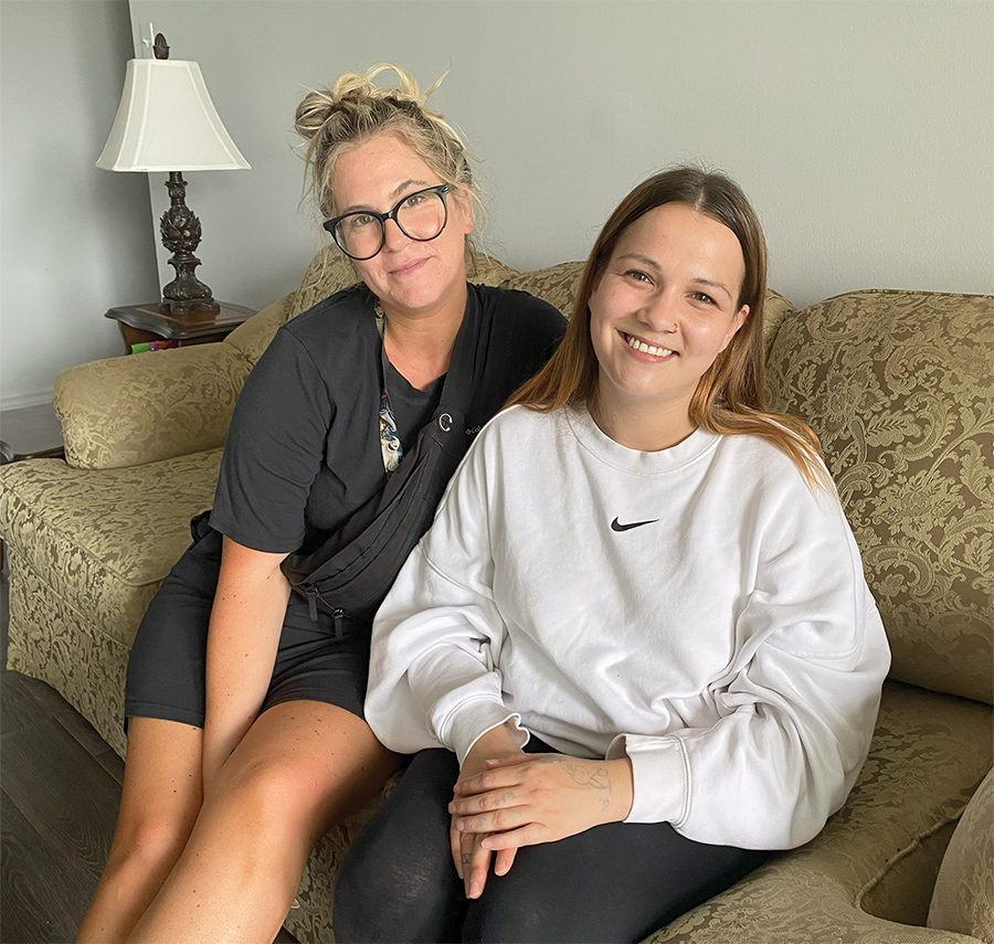 Jasmine, case worker at London Cares, and Shayla sitting on her couch in her apartment