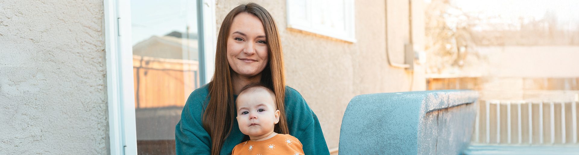 Campaign image, mom and baby sitting on step outside