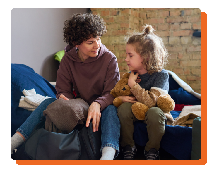 Mom and young girl sitting on bed