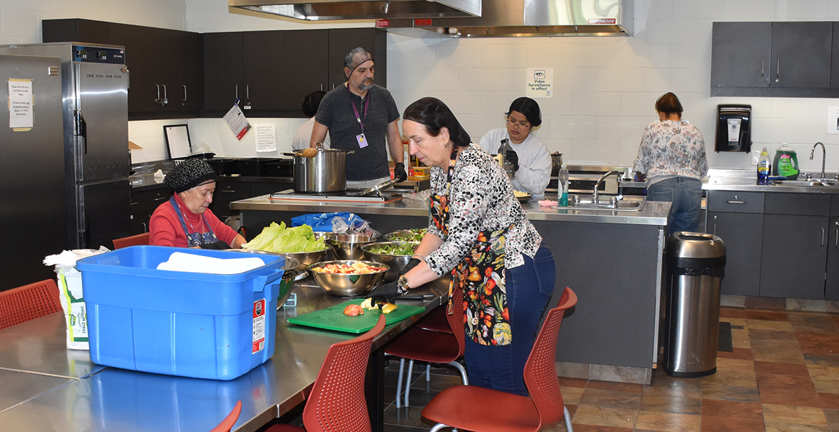 People working in the kitchen at SLNRC in the Essential Services Program