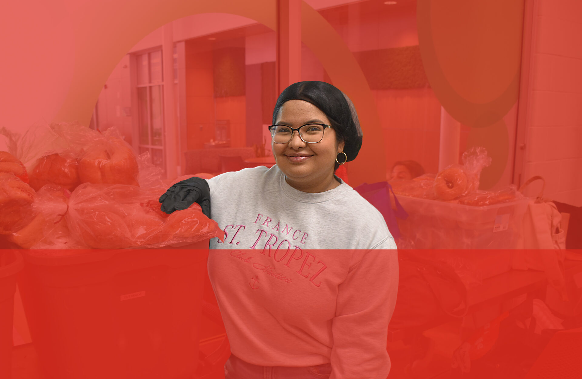 Krisstel, volunteer and part-time worker for the Essentials Services Program on red background